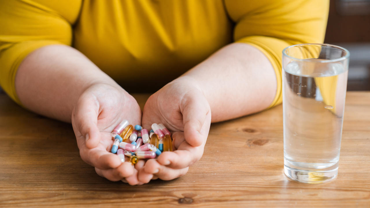 Fat plus size obese young woman sadly eating pills for losing weight in the kitchen. Healthy dieting concept, medicine for burning fat and calories. Image Credit: Adobe Stock Images/InsideCreativeHouse