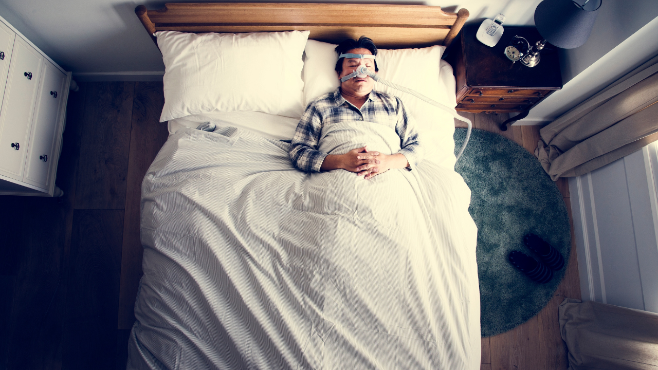 Man sleeping with an anti-snoring mask. Image Credit: Adobe Stock Images/Rawpixel.com