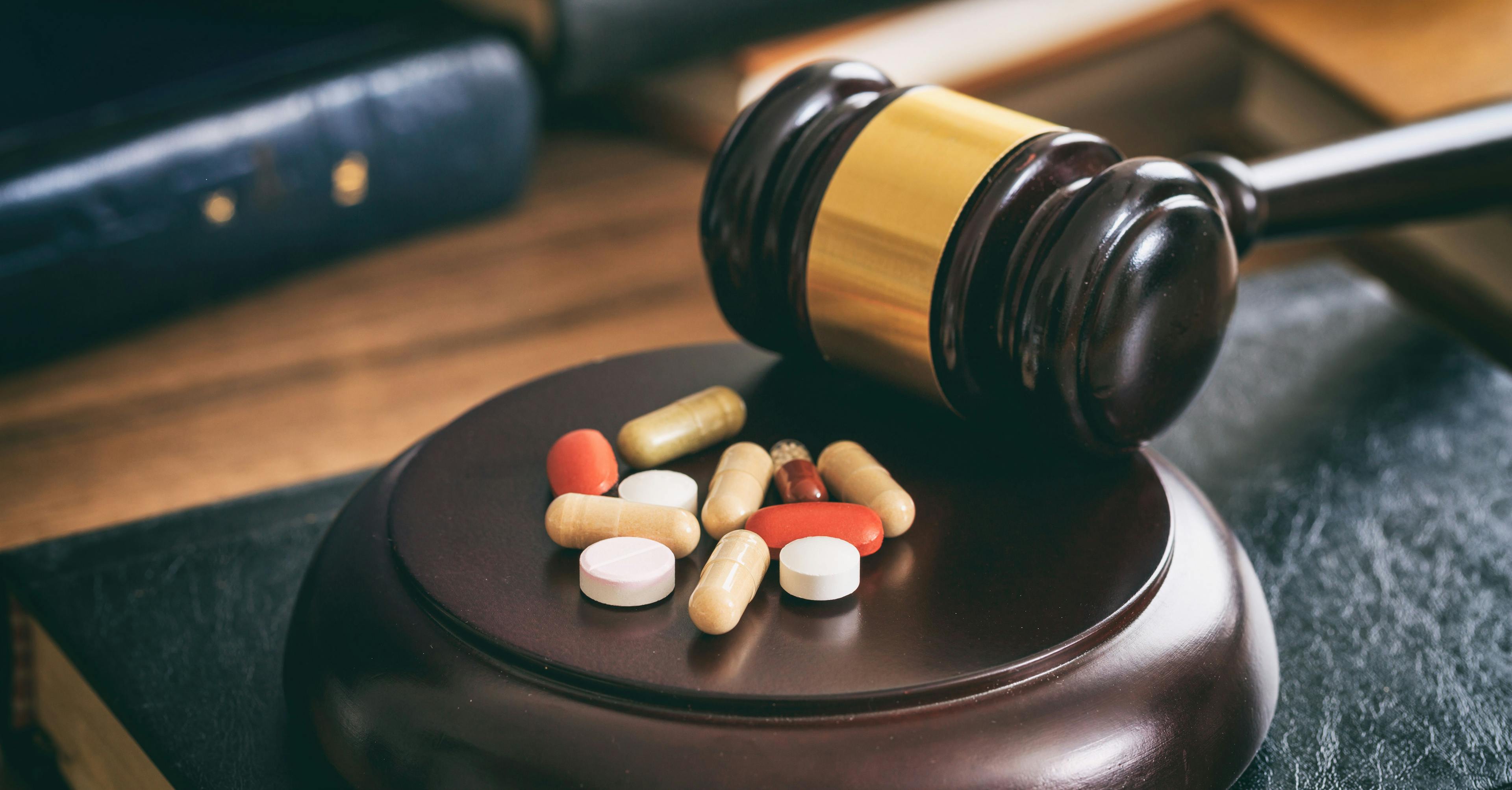 Judge gavel and drugs on a wooden desk. Image Credit: Adobe Stock Images/Rawf8