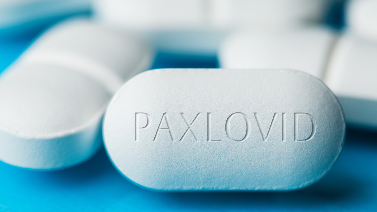 Uzice, SERBIA - Dec 22nd 2021: A pile of Pfizer PAXLOVID antiviral drug pills on blue background,cure for Coronavirus infection,COVID-19 virus disease prevention and protection, illustration. Image Credit: Adobe Stock Images/Milos