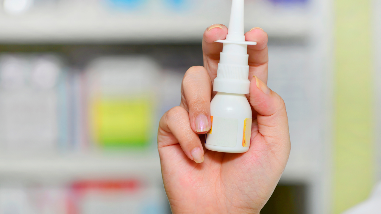 Close up shot pharmacist holding nasal spray medicine at the drugstore.Seasonal health issues. Image Credit: Adobe Stock Images/I Viewfinder