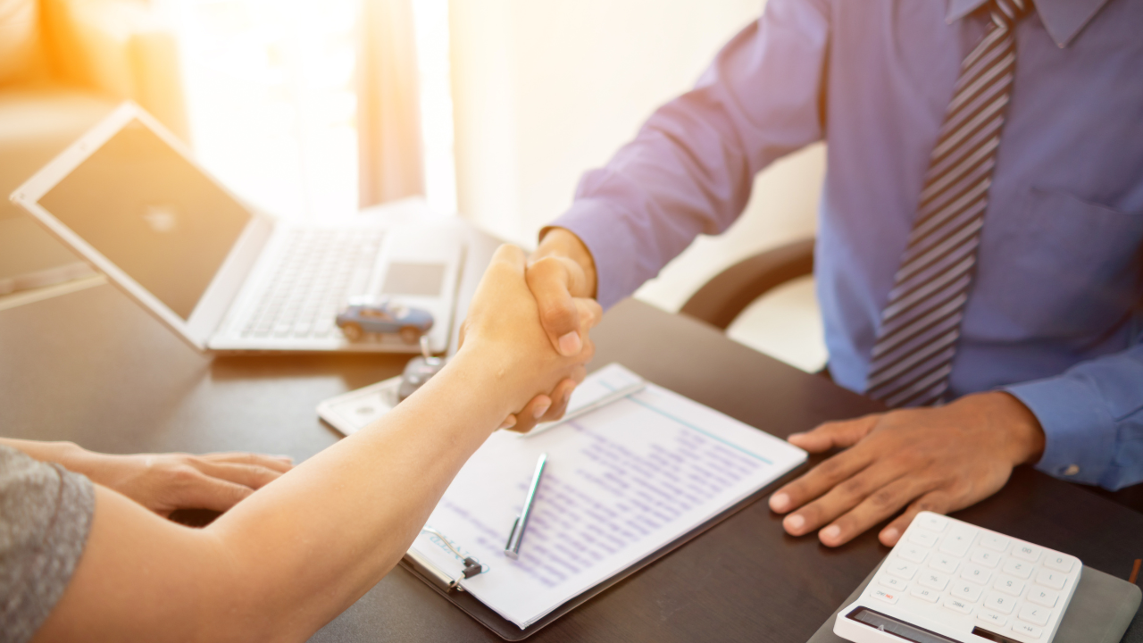 car dealer shook hands with buyer as sign of successful deal and a thank you after the car purchase contract was signed. concept of a handshake to express gratitude after a successful sale contract. Image Credit: Adobe Stock Images/thatinchan