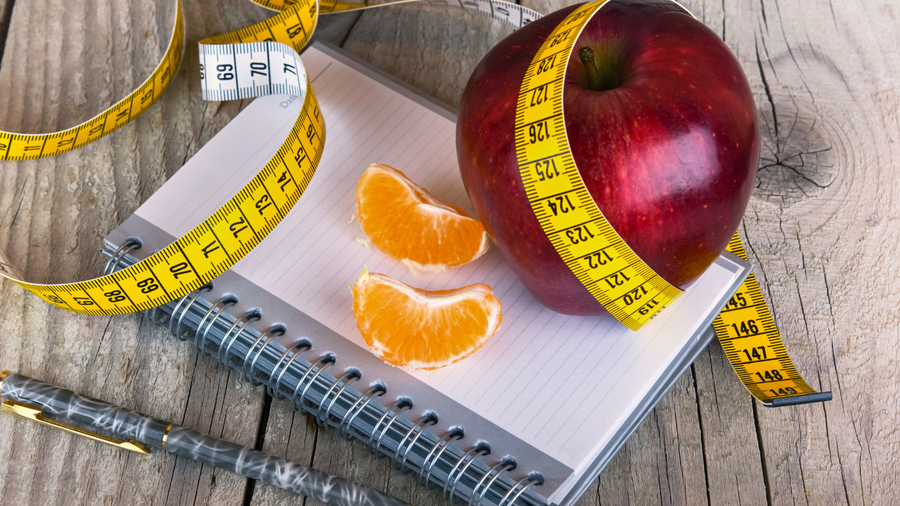 Measuring tape wrapped around a apple weight loss photo. Image Credit: Adobe Stock Images/vician_petar