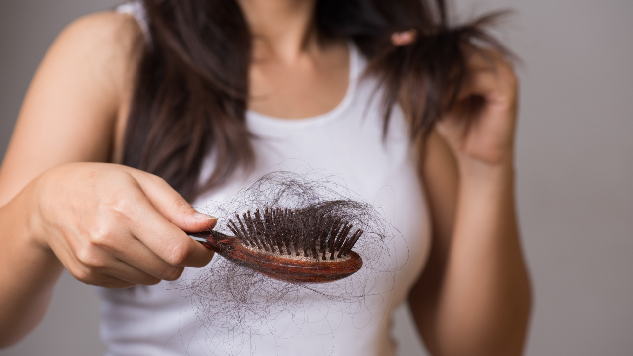 Healthy concept. Woman show her brush with long loss hair and looking at her hair. Image Credit: Adobe Stock Images/Siam 