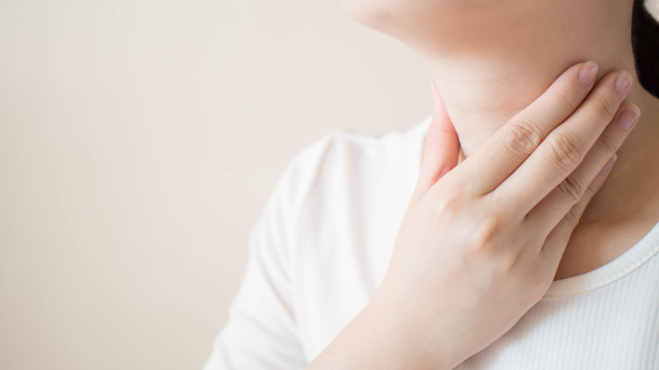 Sick women suffering from sore throat on gray background w/ copy space. Causes of throat pain include flu, common cold, bacterial infections, allergies, smoke, GERD or tumor. Close up. Image Credit: Adobe Stock Images/Orawan