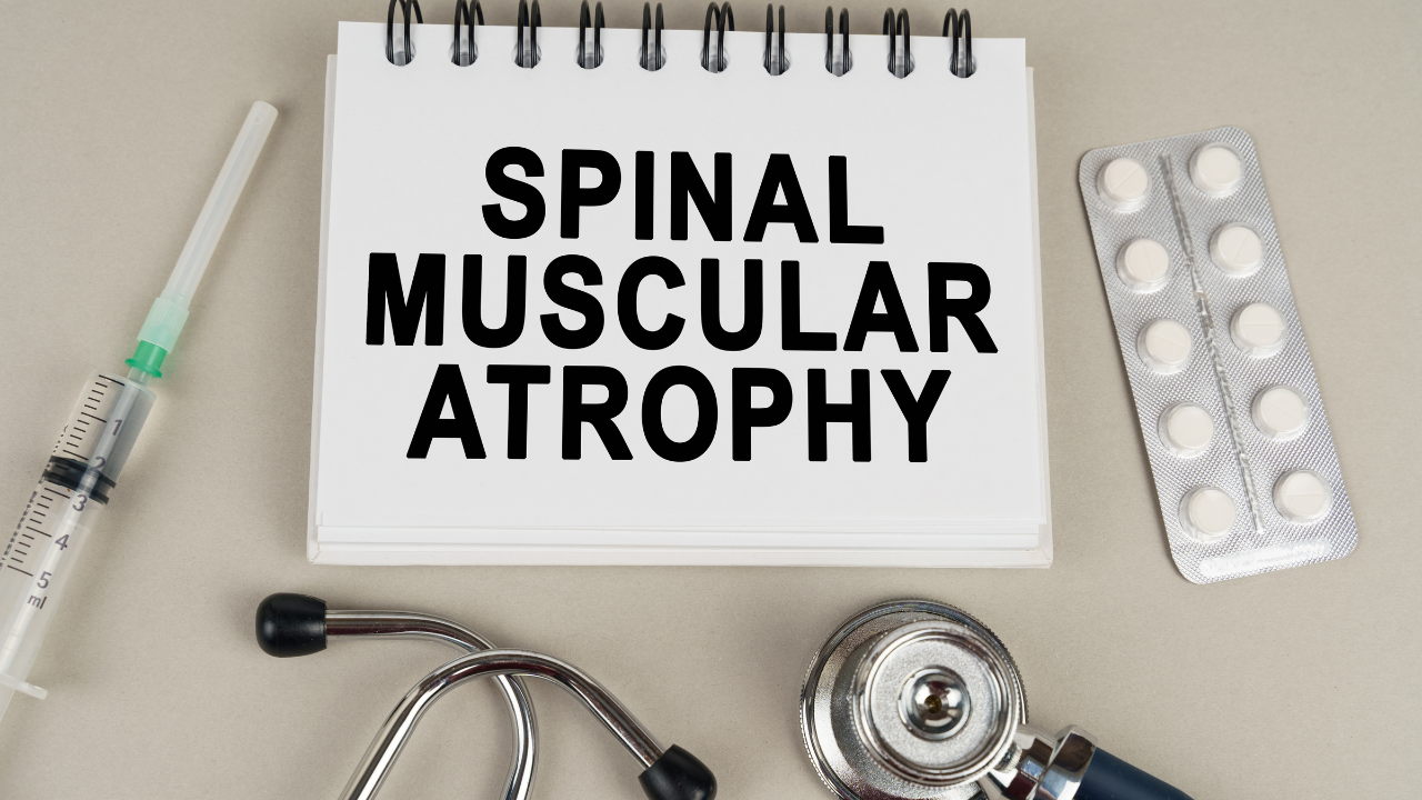 On a gray surface there is a syringe, a stethoscope and a notepad with the inscription - Spinal muscular atrophy. Image Credit: Adobe Stock Images/Dzmitri