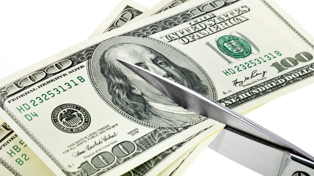 Business concept. Dollars are cutting with scissors. Image Credit: Adobe Stock Images/Garry L.