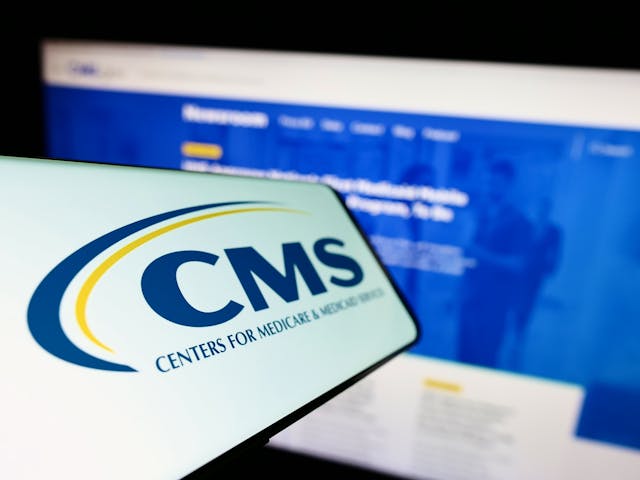 Image credit: Timon | stock.adobe.com. Mobile phone with logo of Centers for Medicare and Medicaid Services (CMS) on screen in front of website. Focus on center-left of phone display