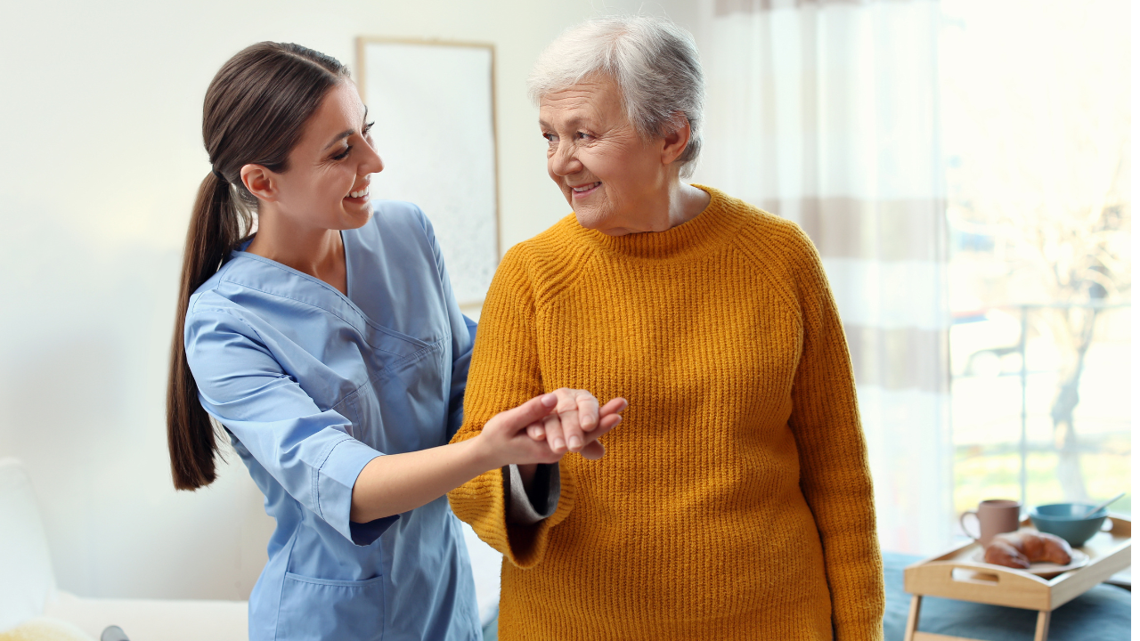 Care worker helping elderly woman to walk in geriatric hospice. Image Credit: Adobe Stock Images/New Africa